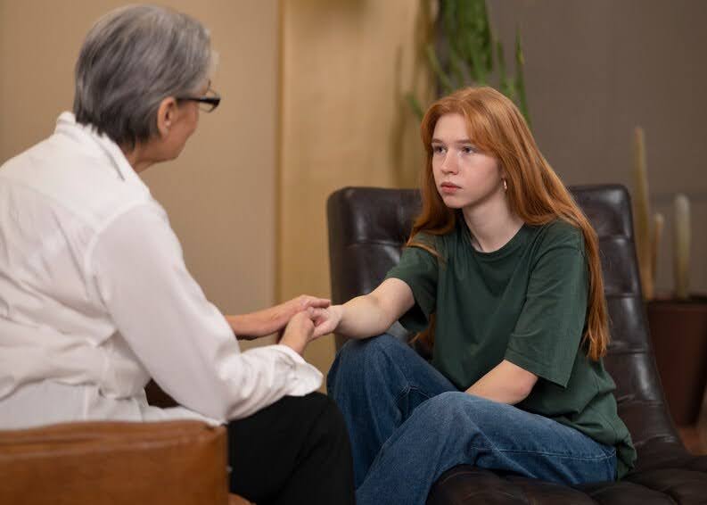  A young lady attentively listens to the words of the psychotherapist.