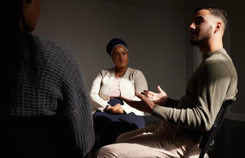 Support group discussing their current struggles in an addiction therapy session. 