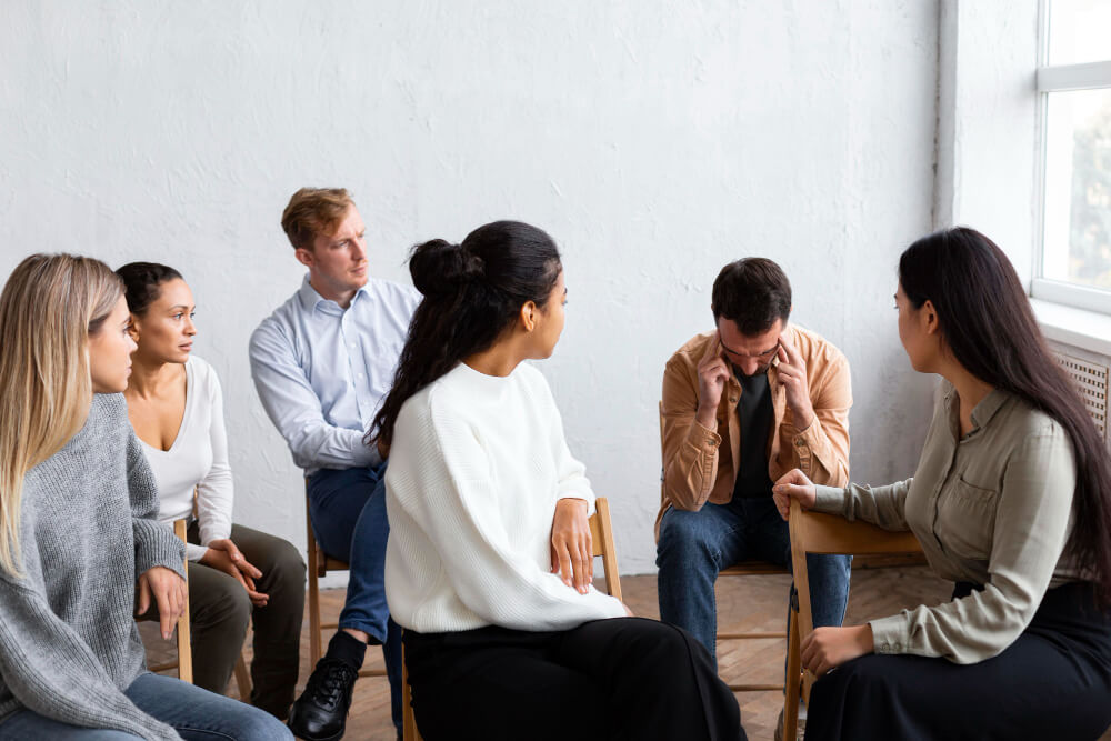 Support group paying attention to one member sharing his story