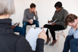 Therapist observing the support group while doing writing therapy - IOP in Miami for mental health