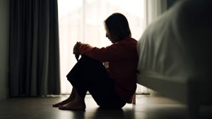 Woman with depression isolating in her room and neeeds the right therapist for depression
